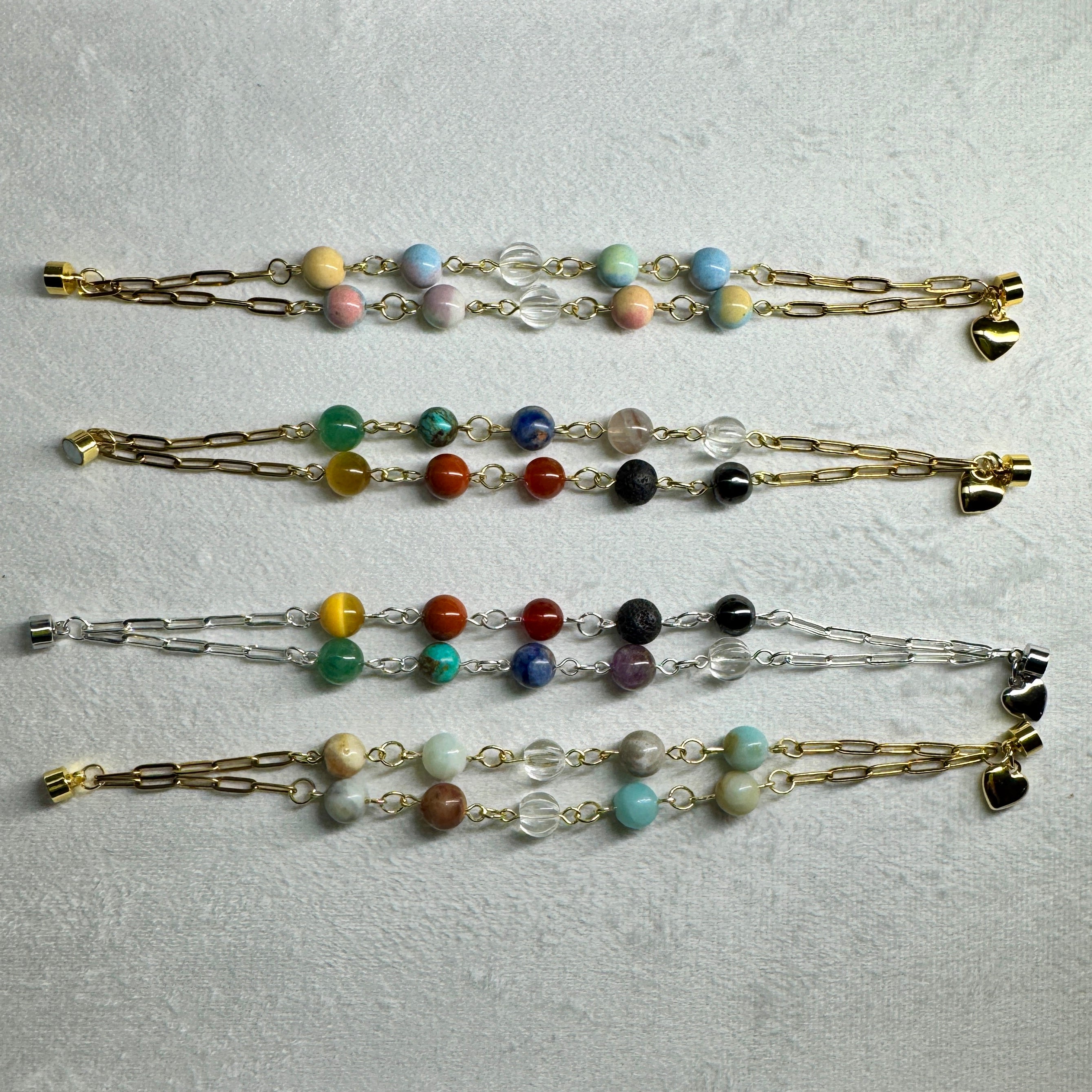 Gem stone bracelets against a velvet light grey background 