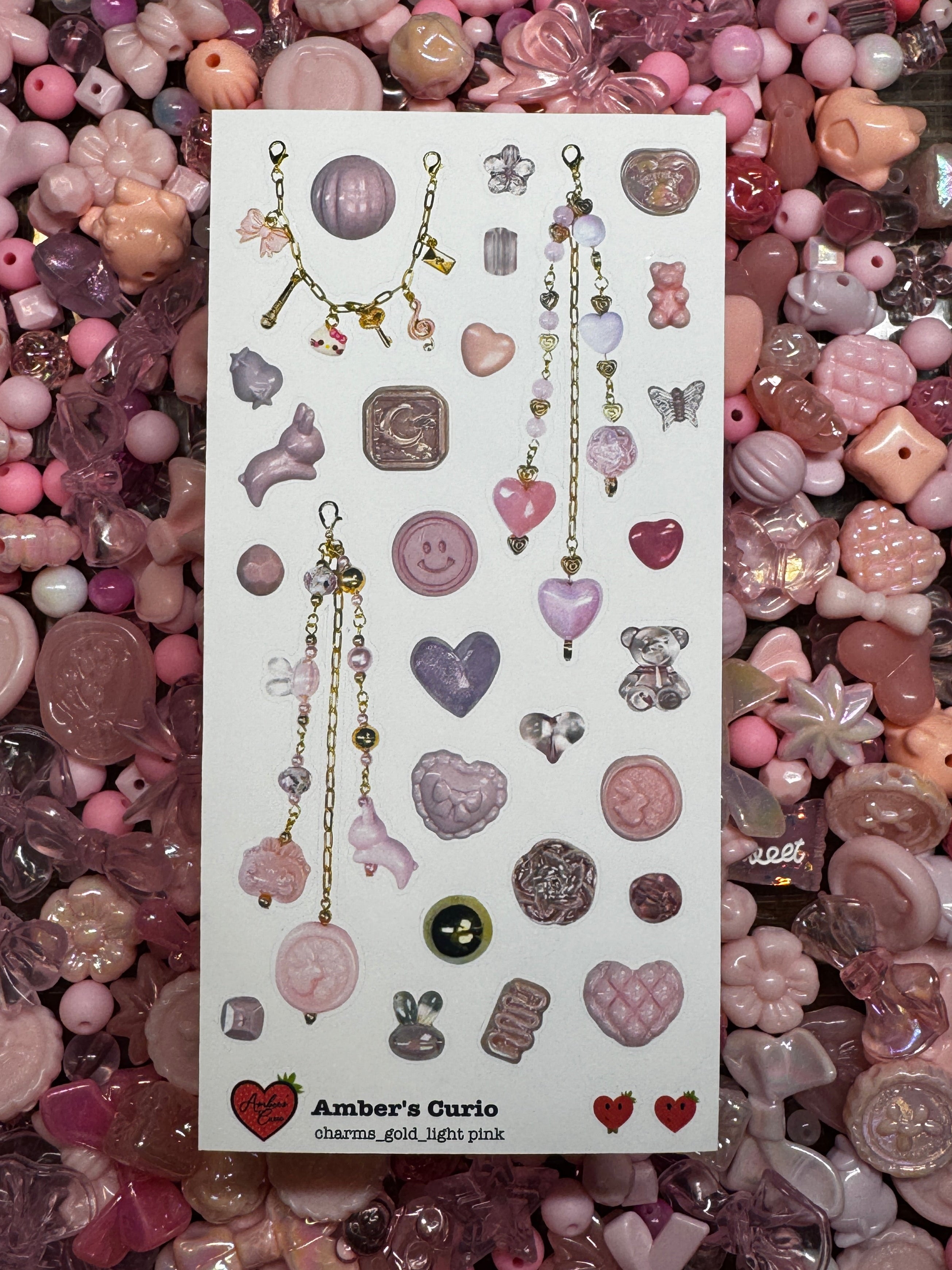 Sticker sheets of photographed light pink beads and charms printed on premium matte paper photographed on top of beads