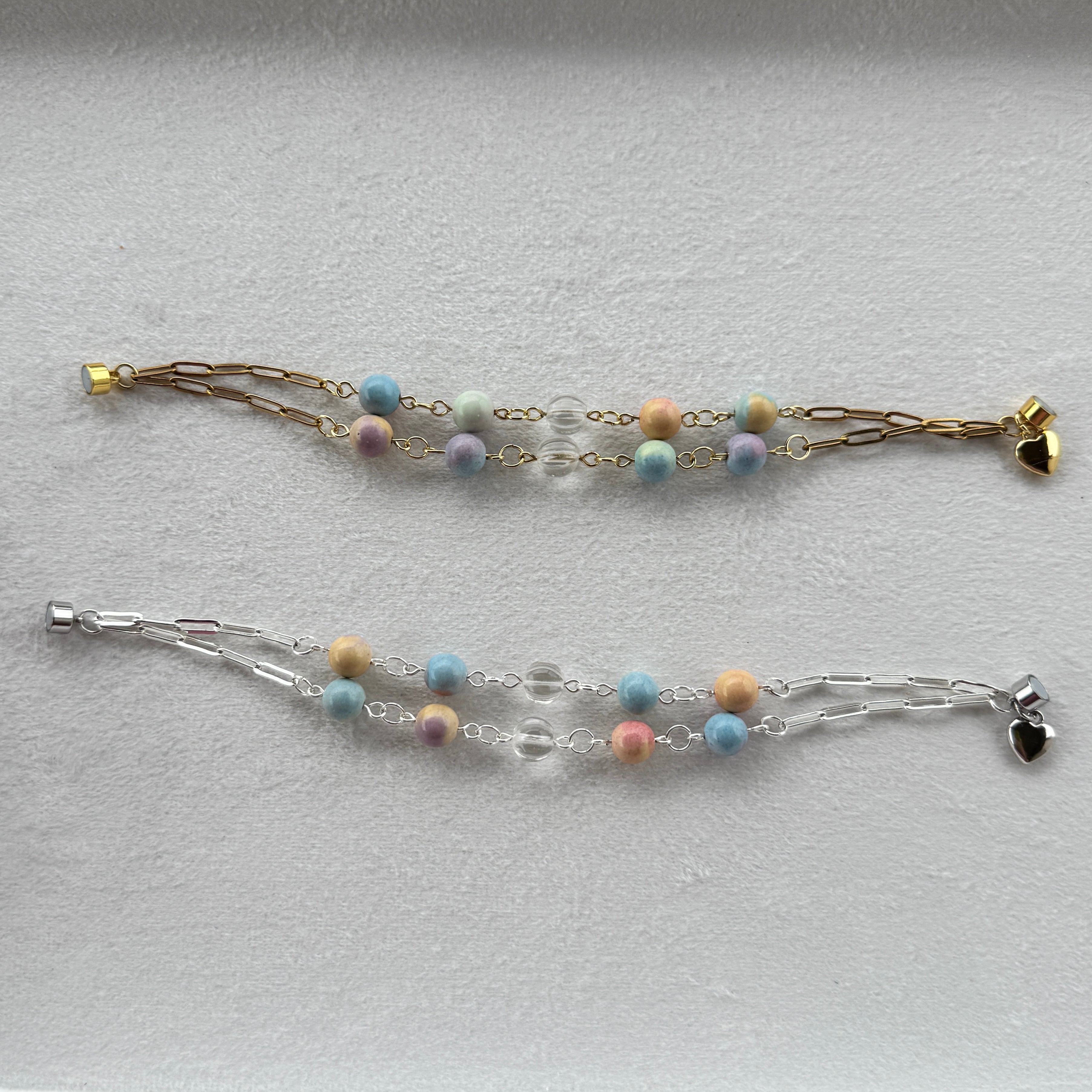 Two beaded bracelets with paperclip chains one in silver and one in gold of Rainbow Alexa Agate gemstones and hand carved clear quartz. 