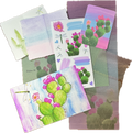 Mail Club Edition 5 spread out on a wooden table displaying prickly pear cactus and dragonfly designs. 