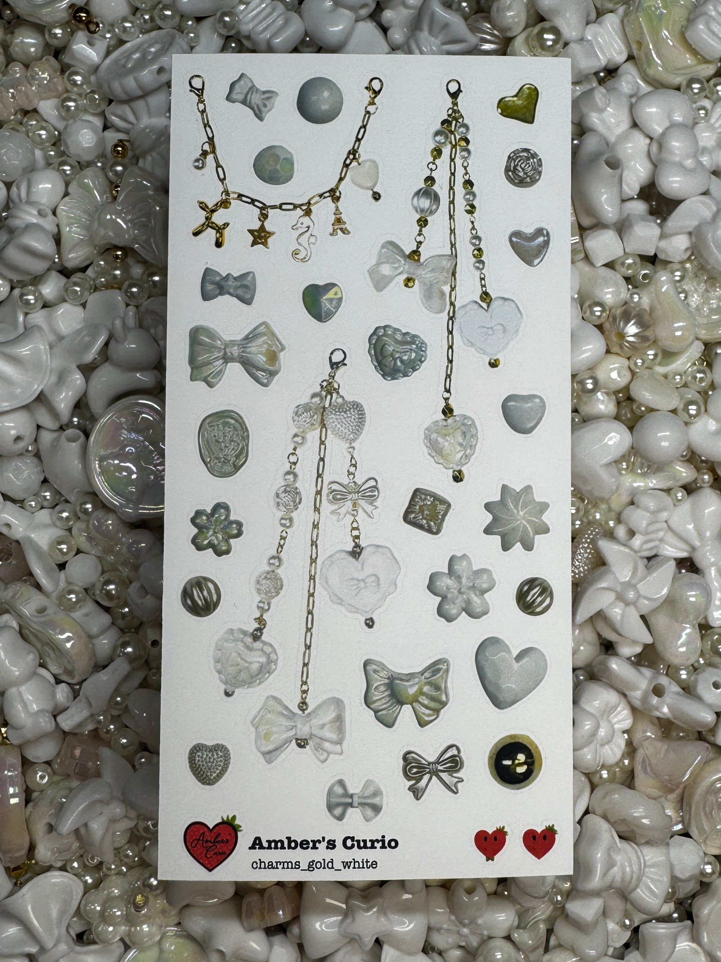 Sticker sheets of photographed white beads and charms printed on premium matte paper photographed on top of beads