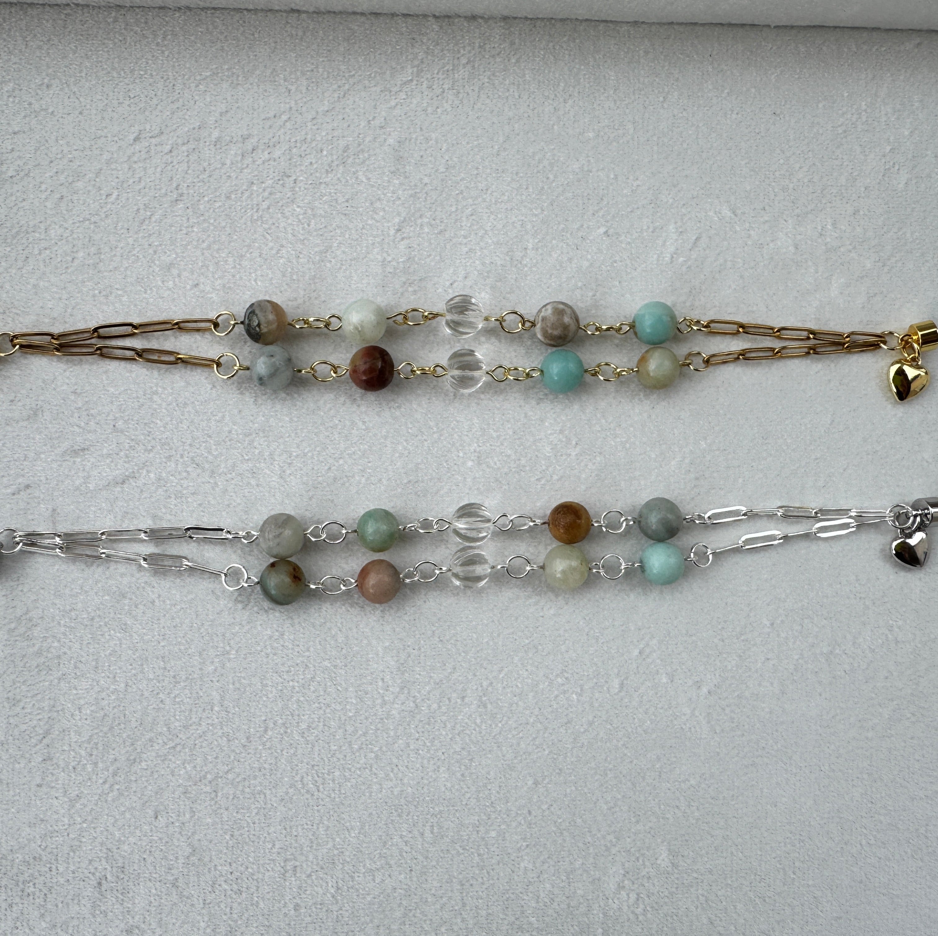 Two beaded bracelets on a light gray surface