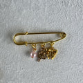 safety pin style brooch gold with a bow and lollipop charm