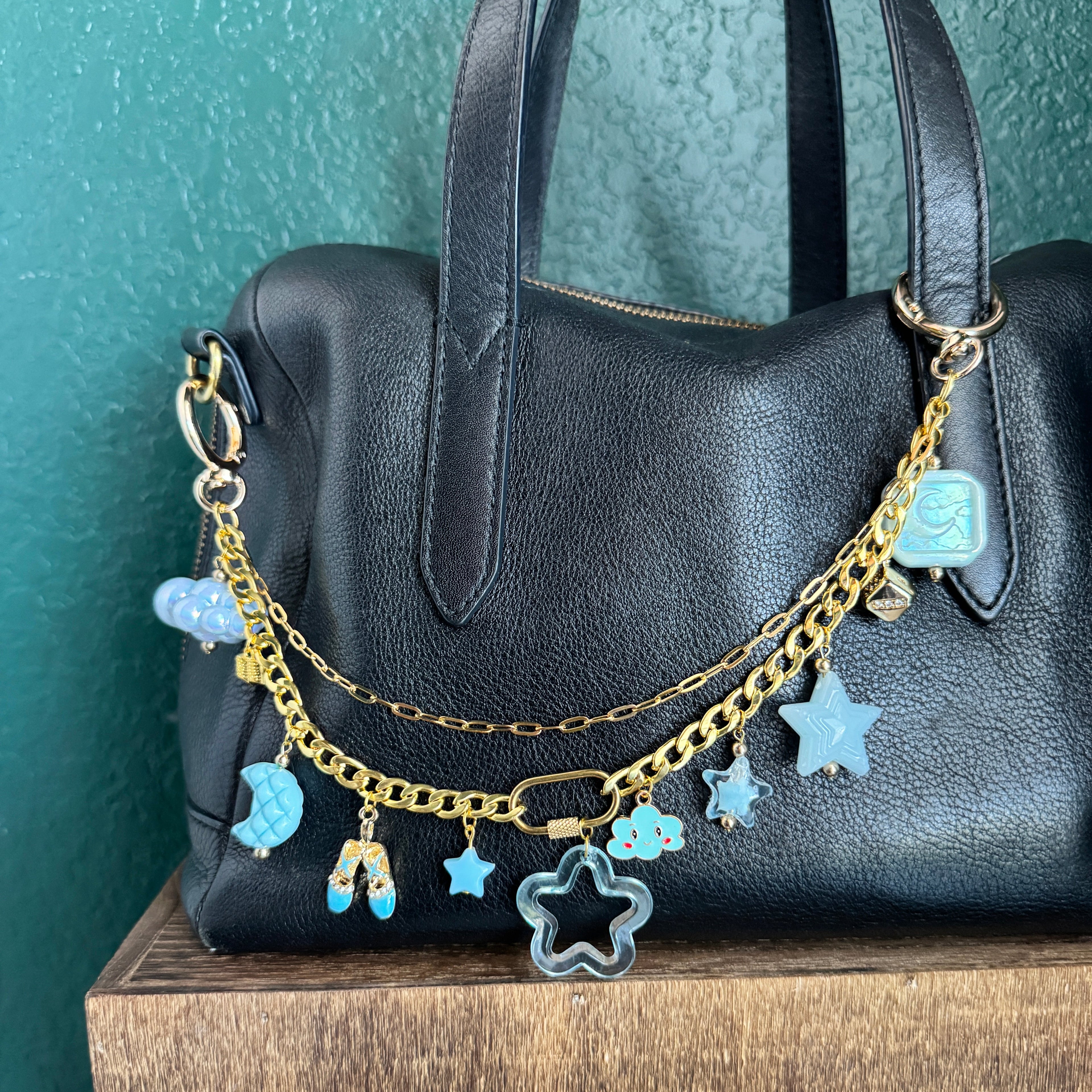bag chain with blue and gold charms has moon and clouds and star themed charms
