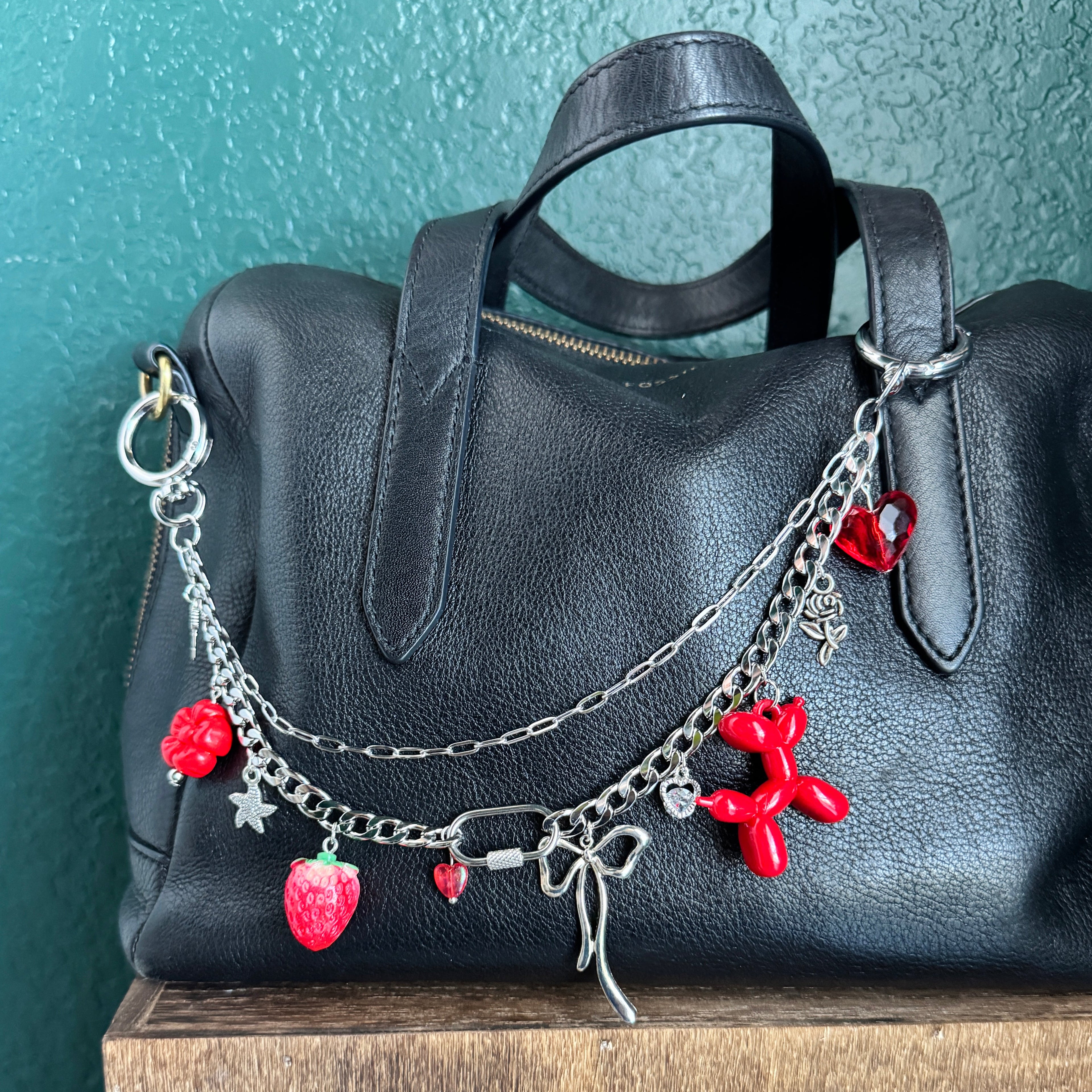 silver bag chain and red charms with red balloon and silver bow 