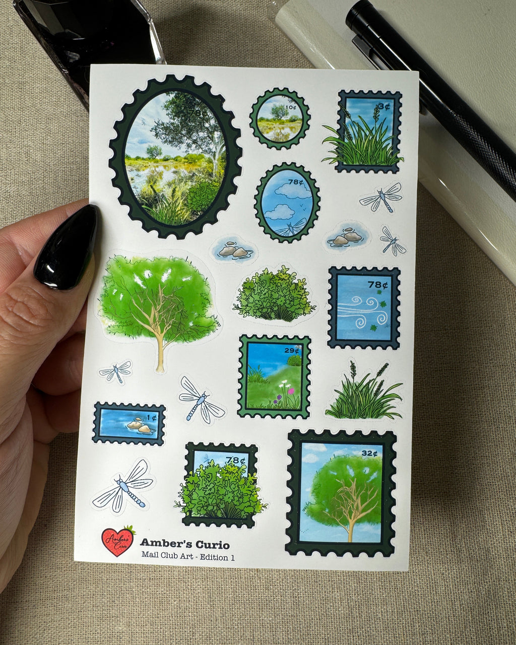 Sheet of nature-themed stamps held by a hand on a textured surface