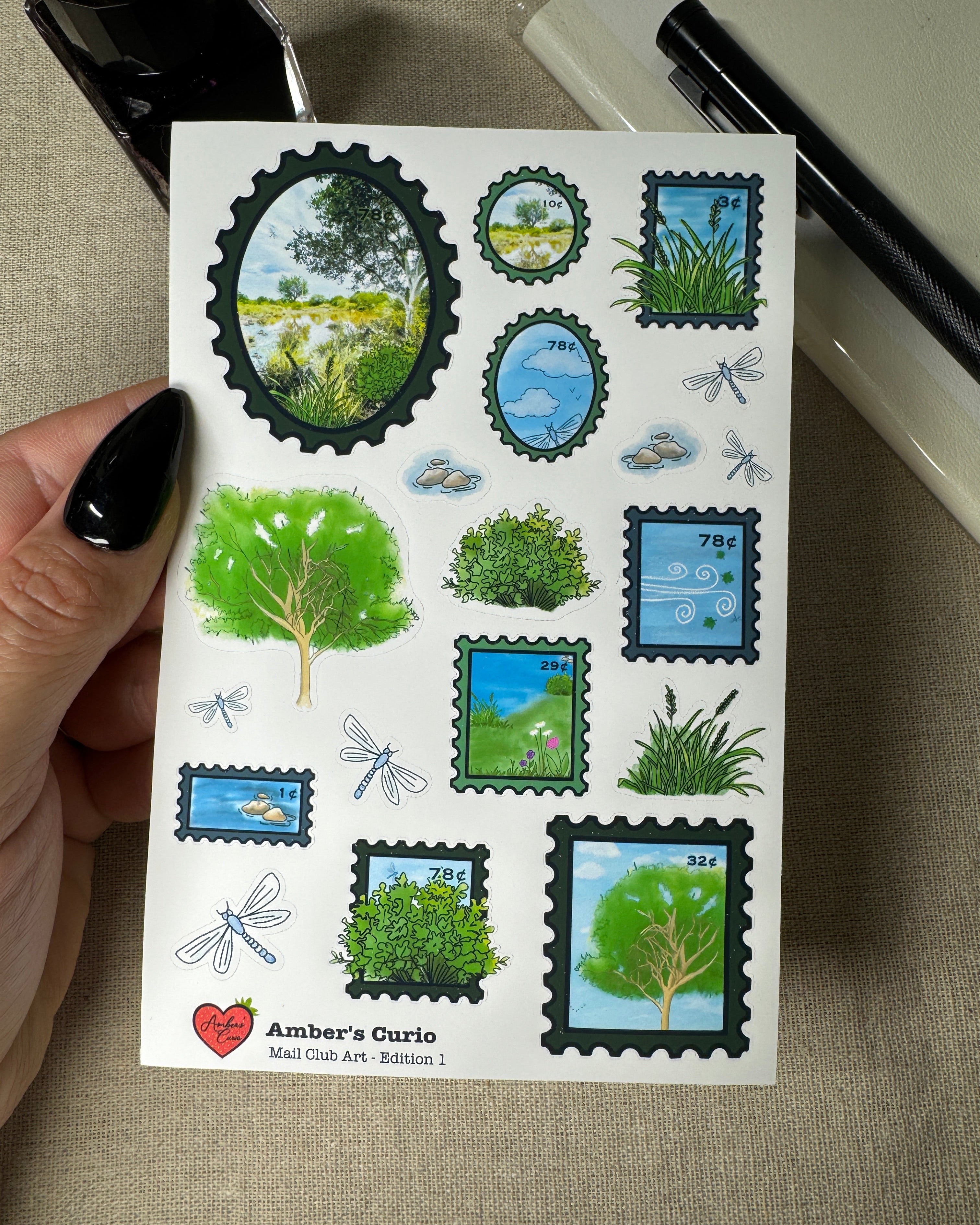 Sheet of nature-themed stamps held by a hand on a textured surface