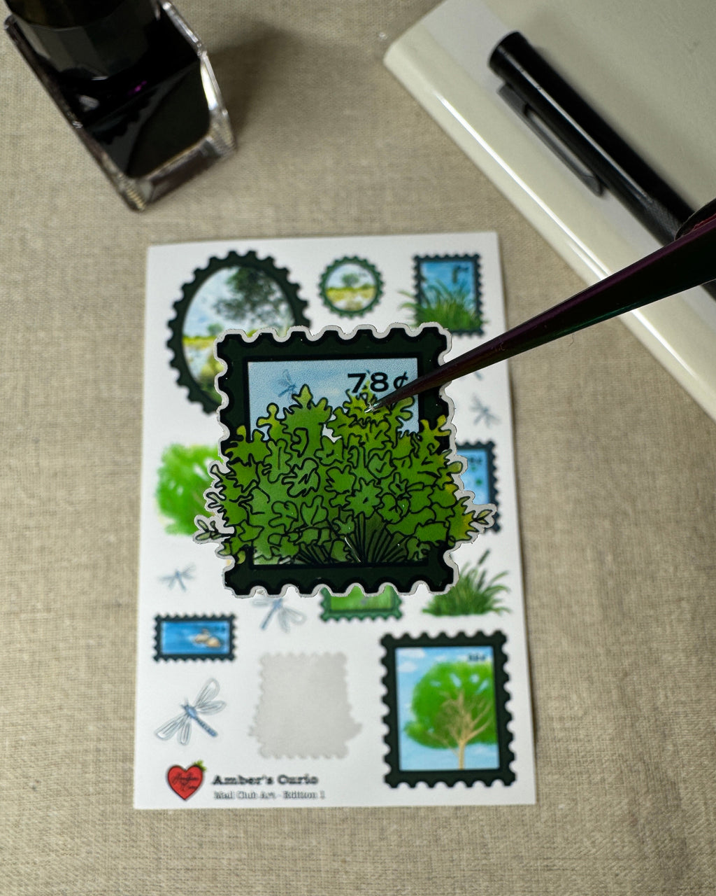 Sheet of stamps with greenery design on a textured surface