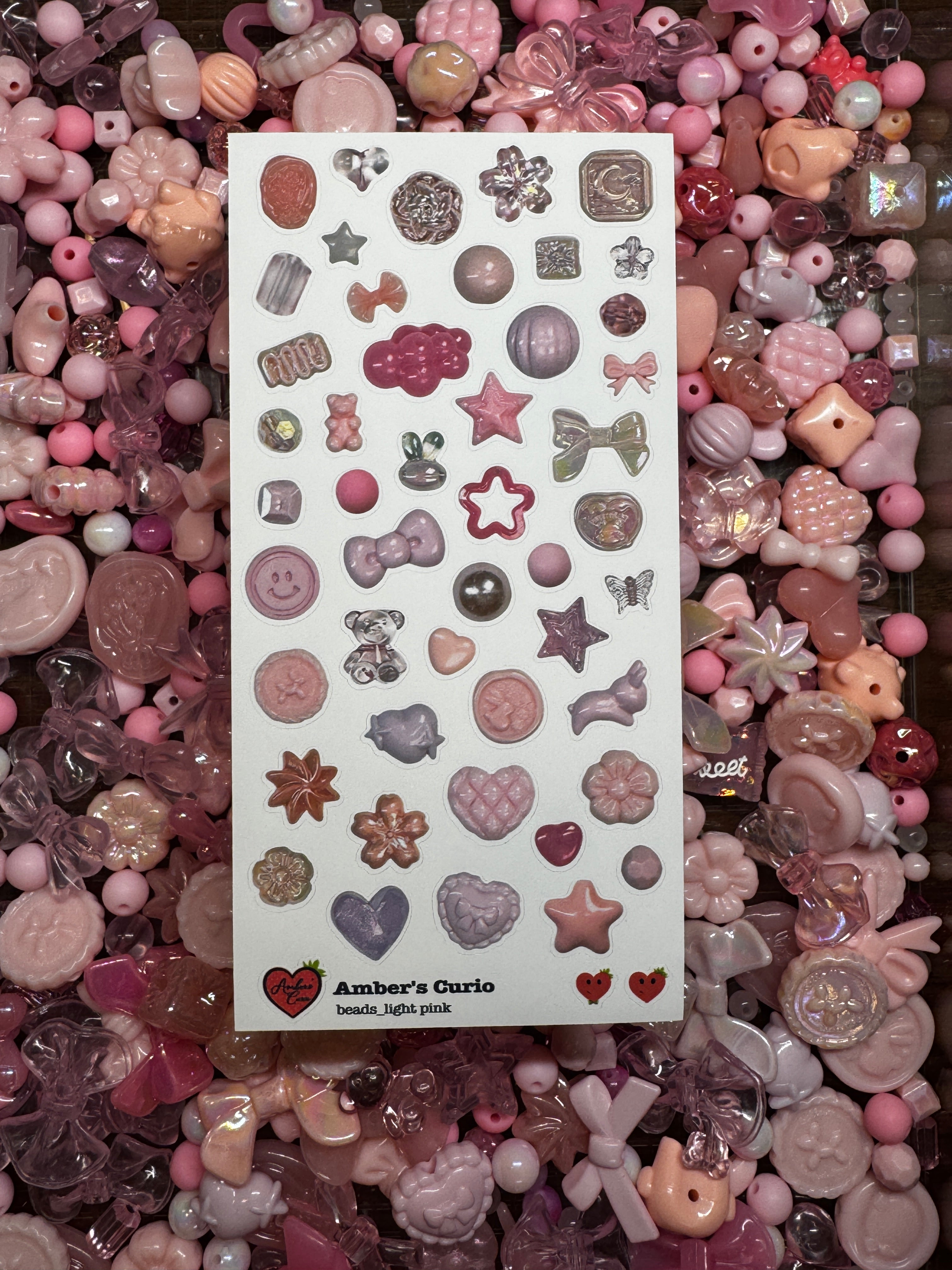 A sticker sheet of photographed pink beads printed on premium matte paper photographed on top of beads